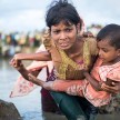 En mamma flyr med sin son över gränsen mellan Myanmar och Bangladesh.