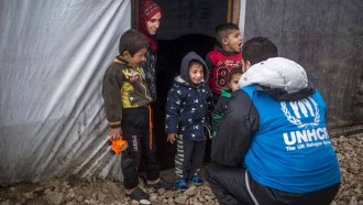 UNHCR:s personal hjälper en familj med vinterhjälp när en snöstorm drar in över flyktinglägret.