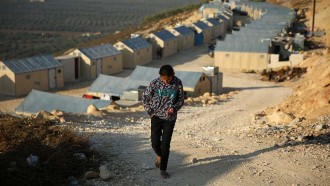 En flicka knallar runt i ett flyktingläger där familjer bor i flyktinghem i stället för i tält.