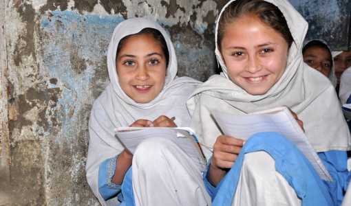 Två flickor från Afghanistan har fått skolpaket och möjlighet att gå i skolan - som de älskar..