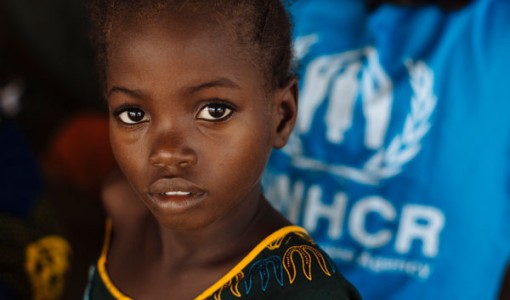 Flicka på flykt får hjälp av UNHCR.
