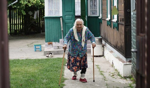 Halyna går runt i sin trädgård. Hennes hus förstördes i ryska attckacker och byggdes upp med stöd från UNHCR. 