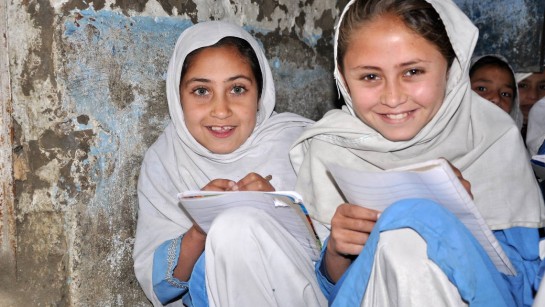 Två flickor från Afghanistan har fått skolpaket och möjlighet att gå i skolan - som de älskar..