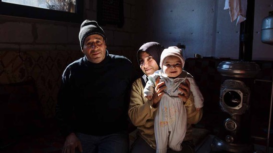 En syrisk pappa sitter med sin familj i en liten kylig och dragit lägenhet i Bekadalen i Libanon. Familjen har fått filtar och vinterstöd från UNHCR. 