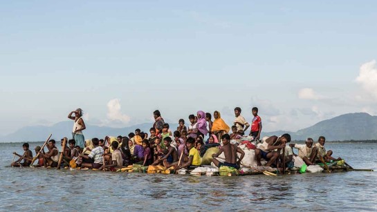 Rohingyer korsar floden Naf River mellan Myanmar och Bangladesh på en hemmagjord flotte. De är på mot flyktingläger i Bangladesh.