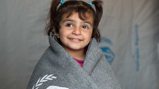 Amina från Syrien har fått en varm filt från UNHCR.