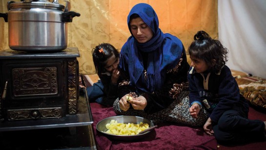 Aisha och hennes två döttrar är på flykt från Syrien. Här lagar de mat i sitt tält i Bekadalen i Libanon. Vinterstormar har svept över dalen och livet i tält svårt och kallt.