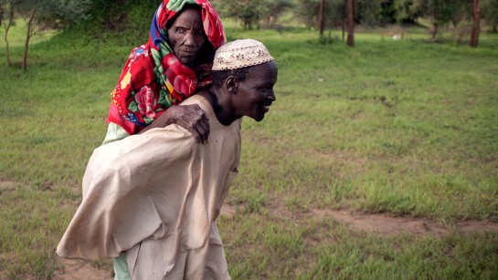 Awad bär sin mamma Dawa Musa på ryggen för att nå säkerhet. 