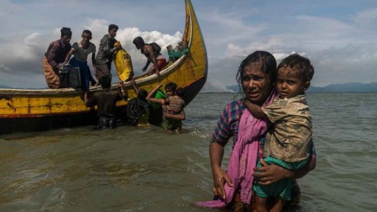 Rohingya-flyktingar från Burma hoppar av en båt vid en strand i Dakhinpara, Bangladesh. September 2017 