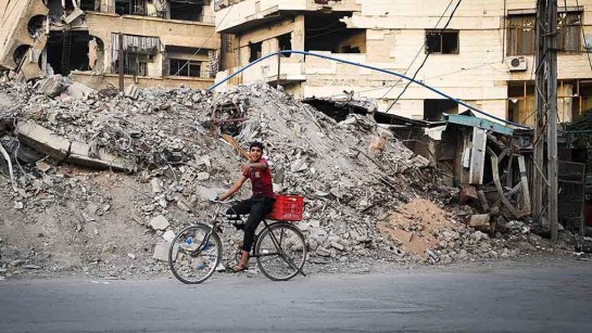 En pojke cyklar runt i sönderbombade Harasta, en förort till Damaskus. En hjälpkonvoj med förnödenheter nådde den belägrade förorten 29 oktober 2016. 
