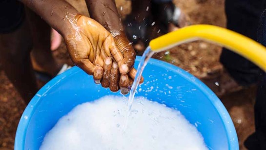 En hemvändande flykting från Elfenbenskusten tvättar händerna efter utbrottet av ebola 2014.