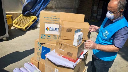UNHCR:s fältarbetare packar hjälppaket som ska minska spridningen av Covid-19 i Iran. Paketen packas med tvåt, pappershandukar och termometrar.