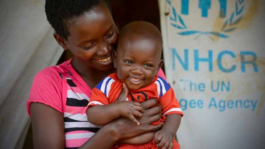 Jacqueline kramar om sin nyfödda son utanför sitt hem i ett flyktingläger i Tanzania. Passa på att hjälpa mammor som lever på flykt. 