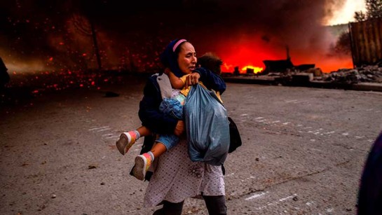 En kvinna håller en flicka när de flyr från elden som brinner i Moria-lägret på den grekiska ön Lesbos den 9 september 2020. 