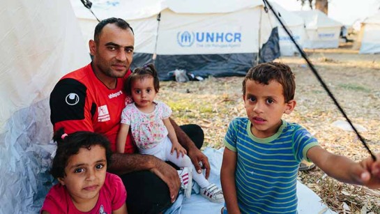 Mohammed Sadik Jalani och tre av hans barn är på flykt från kriget i Syrien. Här sitter de utanför sitt tält i det läger som har byggts upp med hjälp från UNHCR. Tusentals hemlösa som flydde från bränderna i Moria-lägret kan nu få tak över huvudet. 