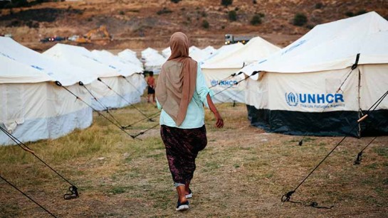 En asylsökande kvinna går runt i ett nybyggt läger efter branden i Moria som förstörde 12 000 människors enkla boenden på den grekiska ön Lesbos i 