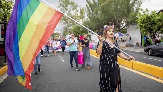 Hbtqi-aktivisten Bianka Rodriguez marscherar med regnbågsflaggan vid en prideparad i San Salvador, El Salvador.