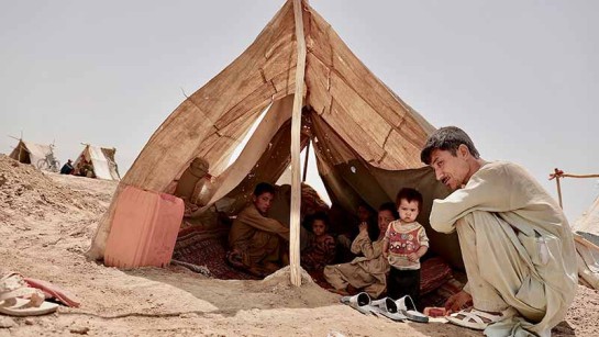 Mohammad Faiz sitter vid sitt lilla tält som han delar med sin familj som är på flykt från strider i Afghanistan.