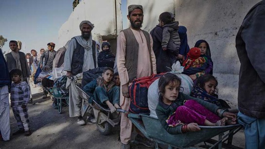 Afghanska familjer köer för att komma in i Pakistan vid gränsövergången Spin Bolak 12 december. 