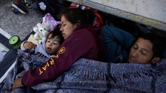 En familj på flykt tar en vilopaus i den mexikanska staden Rio Frio de Juarezas på deras resa mot Mexiko City, 11 december. 