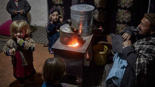Familjen i Kabul värmer sig framför kaminen.