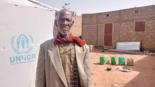 Lambda står framför sitt hem, där han välkomnar flyktingar, i Burkina Faso - ett land som ligger i Sahel.