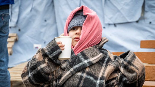 Ett flyktingbarn från Ukraina får varm dryck innan flykten går vidare till Rumänien.