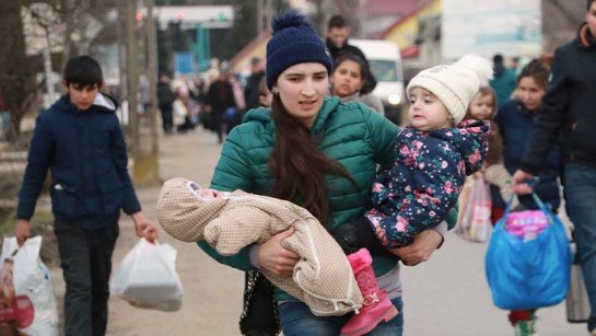 En ung mamma från Ukraina flyr med sina barn över gränsen till Ungern.