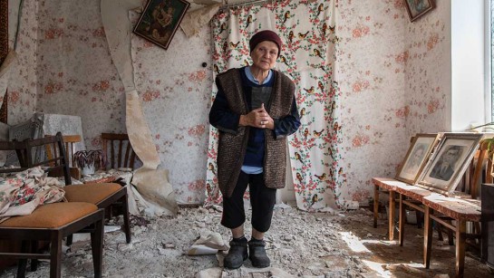 Liudmyla, 65 år, står i sitt förstörda hem i Makariv, Bucha. Hon bor med sin mamma Vira, 85 år, och är upprörd när hon står i ruinerna av sitt hem och visar familjefotografier.