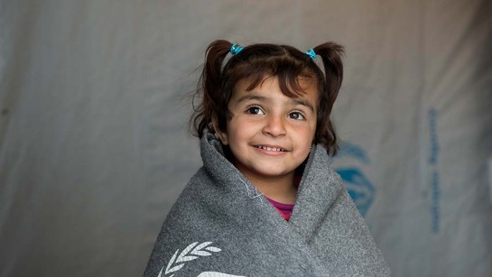 Amani är flyktingbarn från Syrien. Hon bor med sin familj i ett tältläger i Libanon. Hon har fått ett värmande filt från UNHCR.
