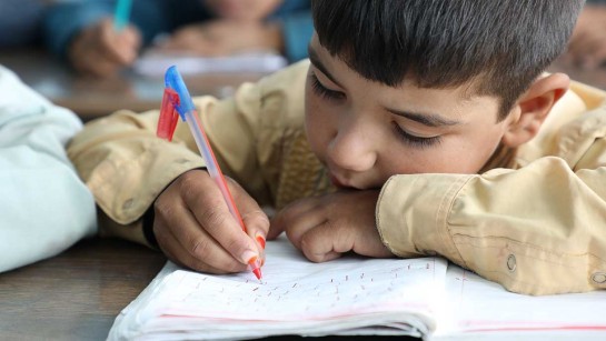 Ett barn på flykt går i skolan och lär sig läsa.