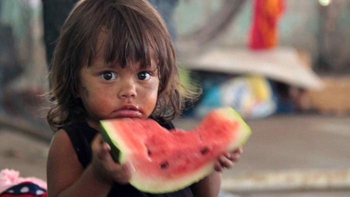 Ett flyktingbarn från Venezuela har fått en vattenmelon.