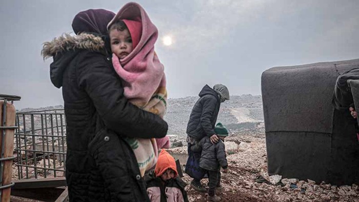 En familj på flykt från bombattacker i norra Syrien en kall vinterdag i februari.