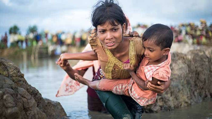 En mamma flyr med sin son över gränsen mellan Myanmar och Bangladesh.