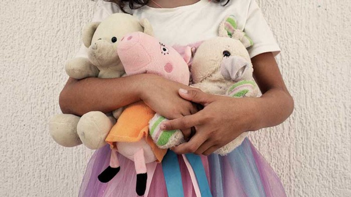 En liten flicka kramar sina gosedjur på ett hem för offer av sexhandel i Colombia. Sexindustrin har förödande följder. Sedan krisen i Venezuela förvärrades har hundratals barn tvingats på flykt, som ökar risken för människohandel.