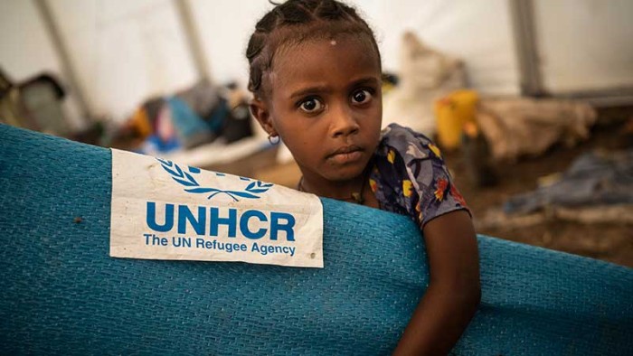 En liten flicka på flykt från Etiopien får nödhjälp i ett gränsläger i Sudan.