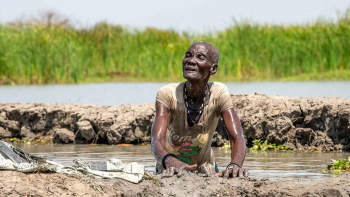 Översvämingar i Sydsudan. En kvinna gräver dike med sina händer.