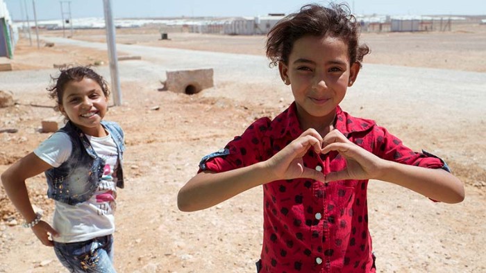 Två flickor leker utanför flyktinglägret Azraq i Jordanien.